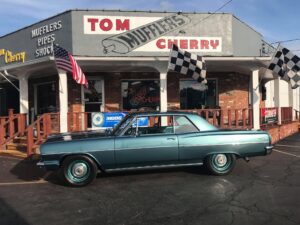 Classic car in front of auto shop